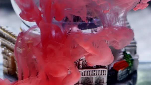 Tinta merah dalam air dengan latar belakang bola salju — Stok Video