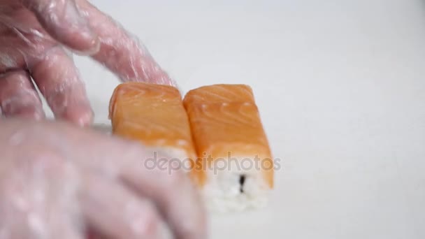 Chef in restaurant preparing and Cutting sushi rolls healthy food — Stock Video