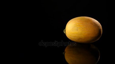 Siyah bir zemin üzerine sarı kavun döner, yakın çekim