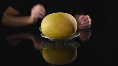 Kavun siyah bir arka plan üzerinde tutan el