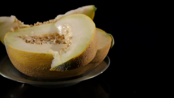 Un melone succoso e luminoso. Mezza polpa matura ruota su fondo nero. Taglia il melone. Ingredienti naturali e biologici — Video Stock