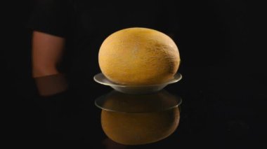 Kavun siyah bir arka plan üzerinde tutan el