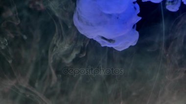 Su koyu arka plan üzerinde renkli mürekkep damlaları