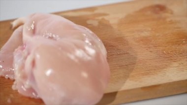2 adet çiğ tavuk fileto düşüyor yavaş hareket, ahşap bir yönetim kurulu