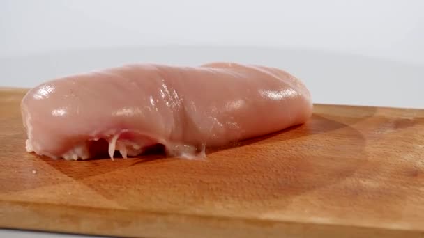 2 adet çiğ tavuk fileto düşüyor ahşap bir gemide bir ahşap tahta el ile alınan daha — Stok video