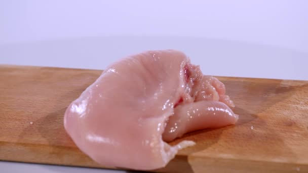 2 bitar av rå kycklingfilé faller på en träskiva, Slowmotion — Stockvideo