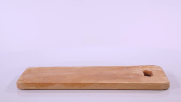 2 trozos de filete de pollo crudo caen sobre una tabla de madera, que se toman de una tabla de madera a mano — Vídeo de stock