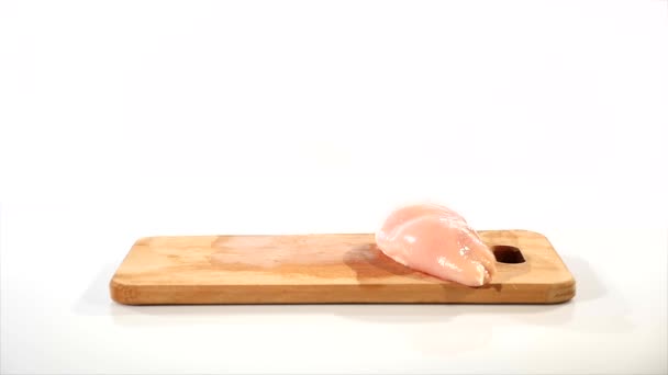 2 κομμάτια από νωπό κοτόπουλο φιλέτο πέφτει σε ένα ξύλινο ταμπλό, από το προέρχεται από μια ξύλινη σανίδα με το χέρι, αργή κίνηση — Αρχείο Βίντεο