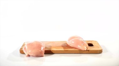 çiğ tavuk fileto Falls bir ahşap tahta üzerinde 2 adet ahşap alınan daha plank el ile ağır çekim
