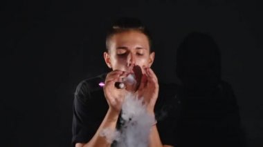 Etkileyici duman halkaları elektronik sigara kullanan genç bir adam tarafından yapılır. Sonunda o en büyük duman daire sağ elini kullanarak bir kamera gönderir