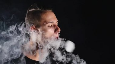 Koyu arka plan üzerinde adam duman Elektrik Sigara