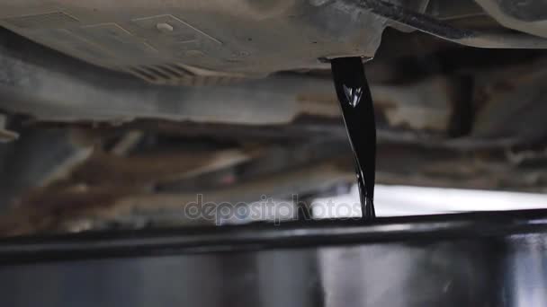 Автомеханик выкачивает масло из автомобиля во время замены масла в обслуживании — стоковое видео