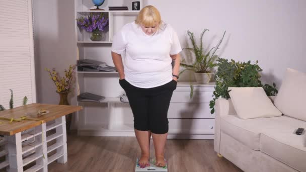 胖女人站到磅秤上 — 图库视频影像