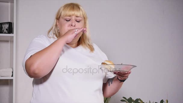 Mujer gorda comiendo una hamburguesa, mirando las escamas y llorando, cámara lenta — Vídeos de Stock