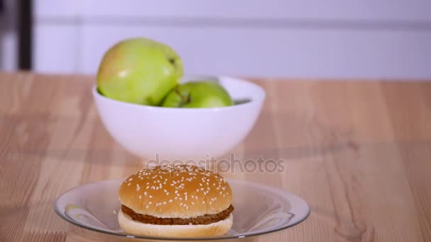 Cerrar las manzanas y hamburguesas en un plato — Vídeos de Stock