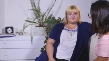 şişman bir kadın bir şey başka bir ince kadın söylüyor