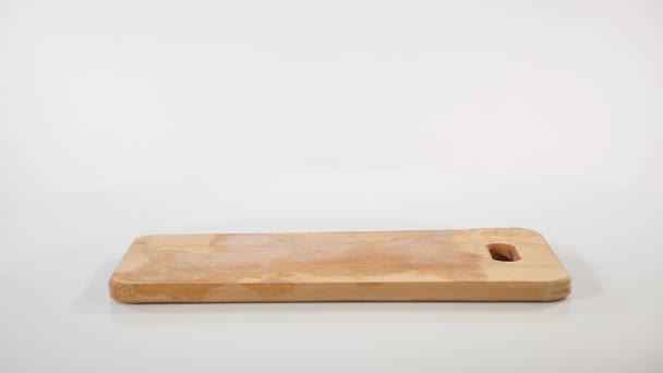 Stukjes rauwe kipfilet valt op een houten plank — Stockvideo