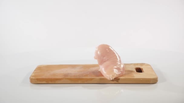 Pezzi di filetto di pollo crudo cade su una tavola di legno — Video Stock
