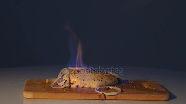Κοτόπουλο φιλέτο στη φωτιά στο ξύλινο ταμπλό. Μπάρμπεκιου κρέατα. Σκούρο φόντο — Αρχείο Βίντεο