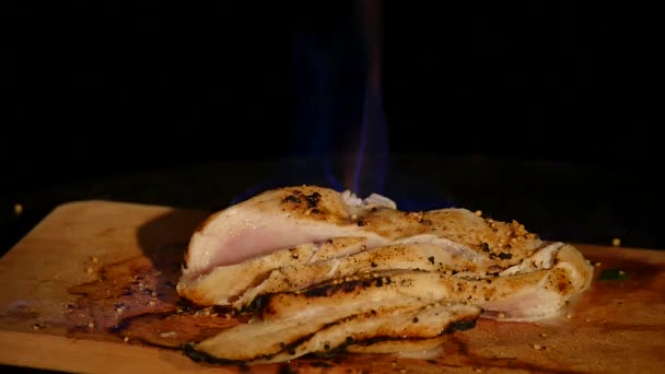 鸡柳燃烧着火焰的木板。烧烤肉。黑暗的背景 — 图库视频影像