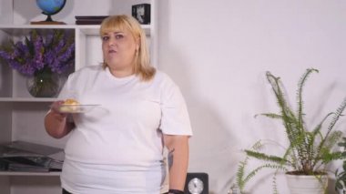 gülümseyen ve dans bir hamburger yeme şişman kadın