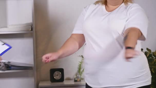 Fet kvinna dansar med en nutritionist — Stockvideo