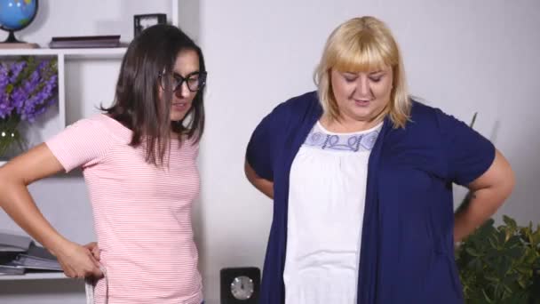 A fat woman and a thin girl measure their own waist — Stock Video
