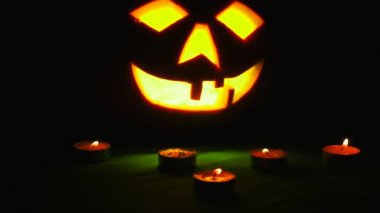 Oyma Halloween balkabağı ışıklar içinde alev yanan mumlar ile siyah bir arka plan ile yakın çekim