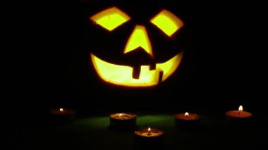 Oyma Halloween balkabağı ışıklar içinde alev yanan mumlar ile siyah bir arka plan ile yakın çekim