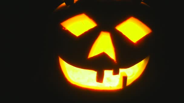 Halloween pumpa med skrämmande ansikte med med en brinnande ljus — Stockvideo