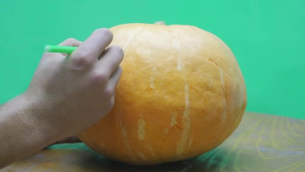 Pan de un niño dibujando la cara de Jack-o-linterna en su calabaza de halloween — Vídeo de stock