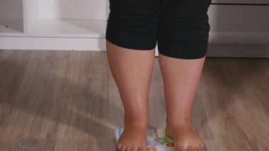 şişman kadın ölçekler üzerinde duruyor ve sevinirler başlar ve dans