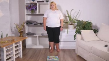 şişman kadın ölçekler üzerinde duruyor ve sınıf gösterir