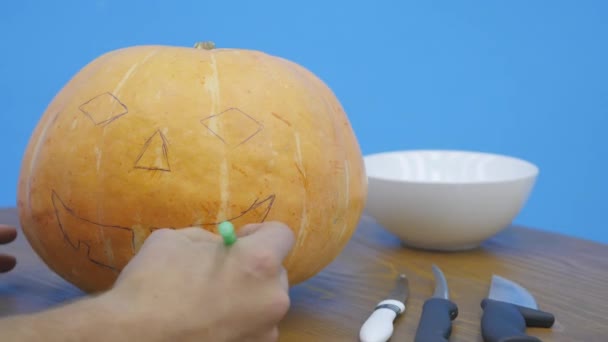 Pfanne eines Jungen, der das Jack-o-Laternengesicht auf seinen Halloween-Kürbis zeichnet — Stockvideo