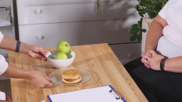 胖女人苹果和汉堡之间进行选择。饮食与健康 — 图库视频影像