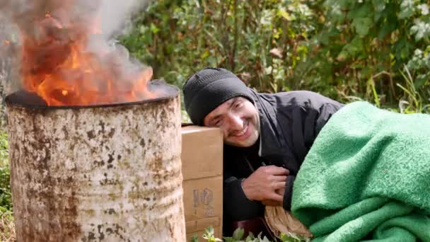 Les pauvres se réchauffent près du feu corbeille et boire de la vodka — Video