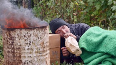 Ateşin yanında uyuyan evsiz bir adam
