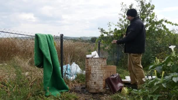 Povera gente che si scalda vicino al fuoco barile della spazzatura e bere vodka — Video Stock