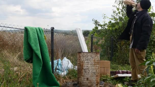 Yoksul insanların yakınındaki ısınma çöp varil ve içki votka ateş — Stok video
