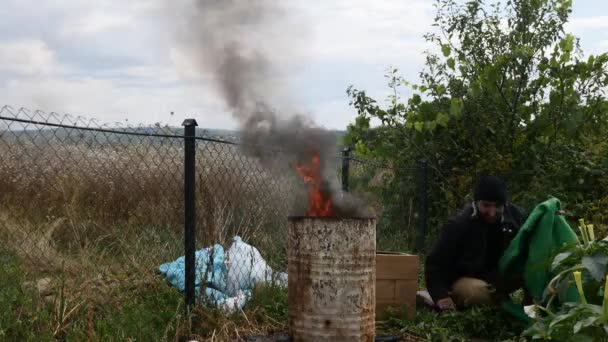 Un vagabundo durmiendo cerca del fuego — Vídeo de stock