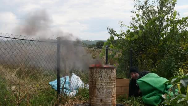 Un vagabundo durmiendo cerca del fuego — Vídeo de stock