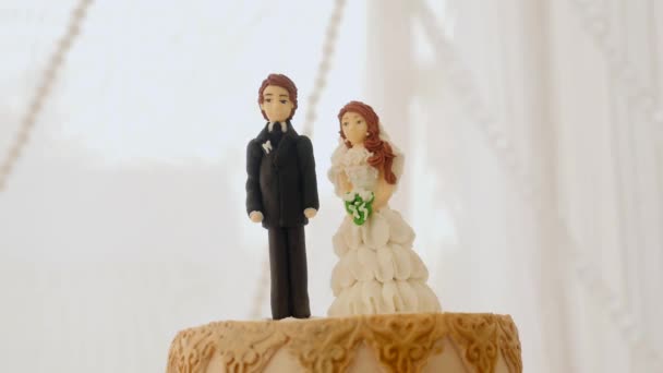 Figuras de novias y novios en pastel de boda sobre fondo parpadeante — Vídeos de Stock