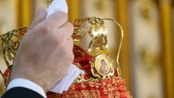 Les témoins tiennent une couronne d'or sur les jeunes mariés. Le prêtre bénit les mariés. Le rite de l'église sur les mariés. Église orthodoxe — Video