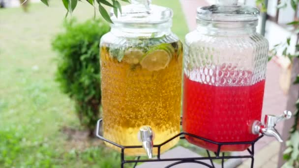 En la Junta dos latas de refresco. Bebidas - limón y lima. Luz difusa. Rebanadas de cítricos en un frasco sobre la mesa. Estilo de vida — Vídeos de Stock