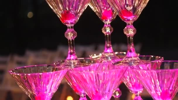 Champagne pyramid. The waiter pours champagne in glasses. The pile of champagne glasses. Festive drinking alcohol. Feast in the restaurant. Holiday. Service of drinks — Stock Video