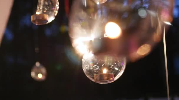 Glass balls with candles hang before the window — Stock Video