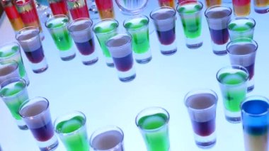 Alkol votka bar gece kulübü. Çekim tren domino taşları gibi düşüyor. Parti canlısı içme, kapatın. Pembe ve mavi renkli içecekler. Doğum günü kutlaması, tavuk veya bekarlığa veda partisi. Meyveli votka