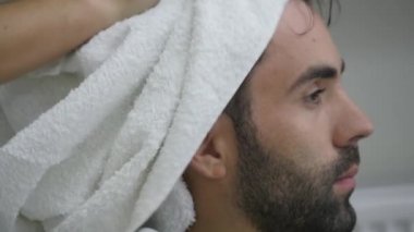 Sakallı genç erkekler başından bir havlu ile silin. Kuaför
