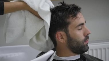 Sakallı genç erkekler başından bir havlu ile silin. Kuaför