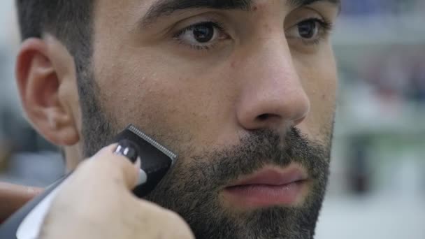 Processus de coiffure. Gros plan d'un coiffeur séchant les cheveux d'un jeune homme barbu — Video